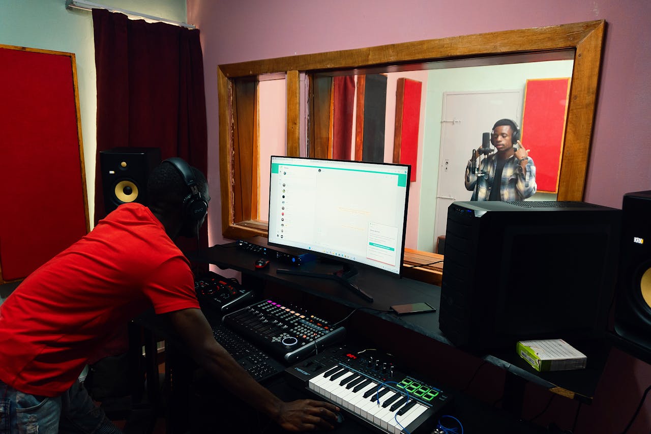 A music producer and artist collaborating in a professional recording studio environment.