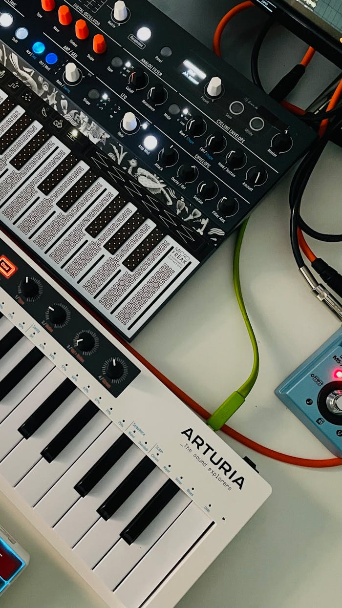 Top view of synthesizers and gear in a modern music production setup.