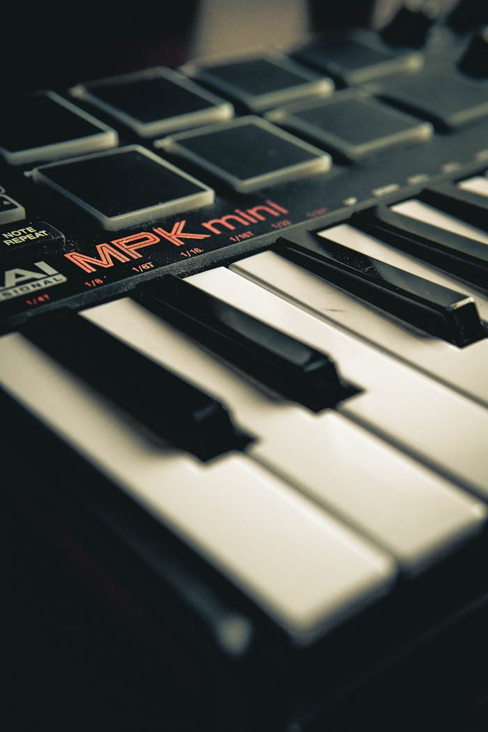Vertical close-up of MPK Mini MIDI controller and piano keys, ideal for music production themes.